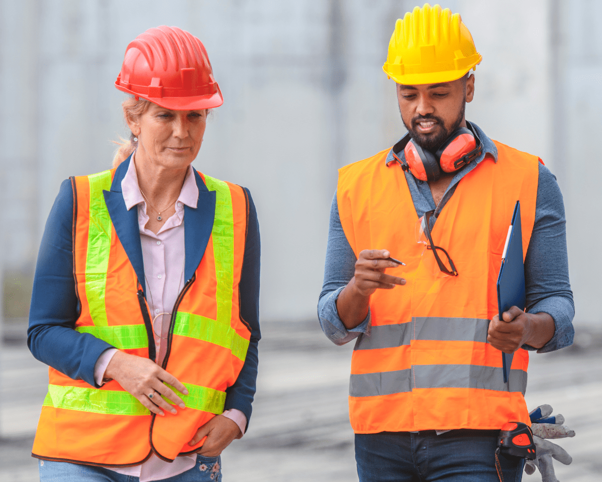 two construction workers wearing safety vests and hard hats