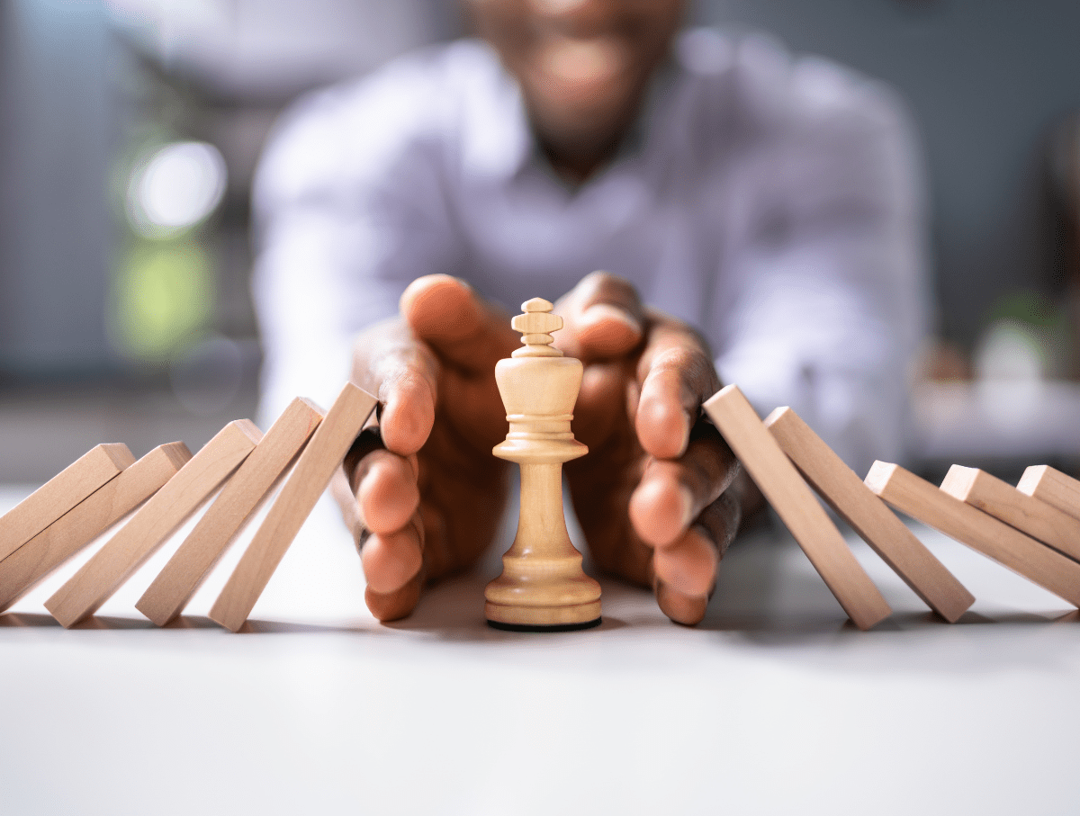 a person holding a chess piece in front of dominos
