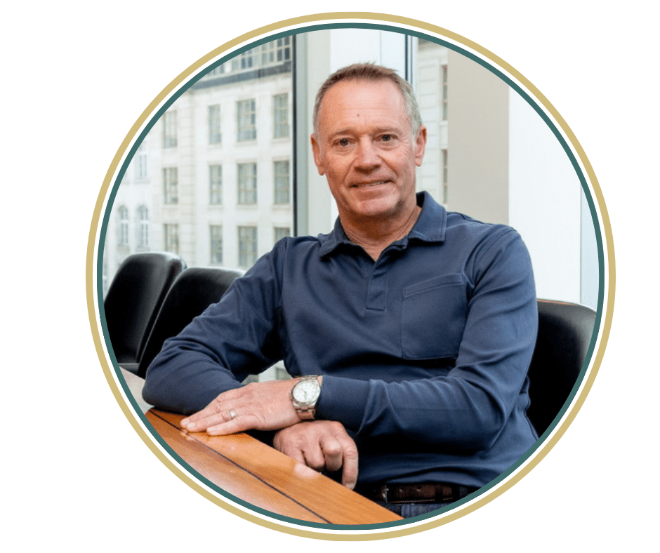 head shot of Phil Barrett in a circle frame with green and gold border