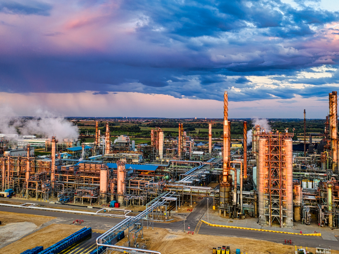 An oil refinery at sunset with clouds in the background