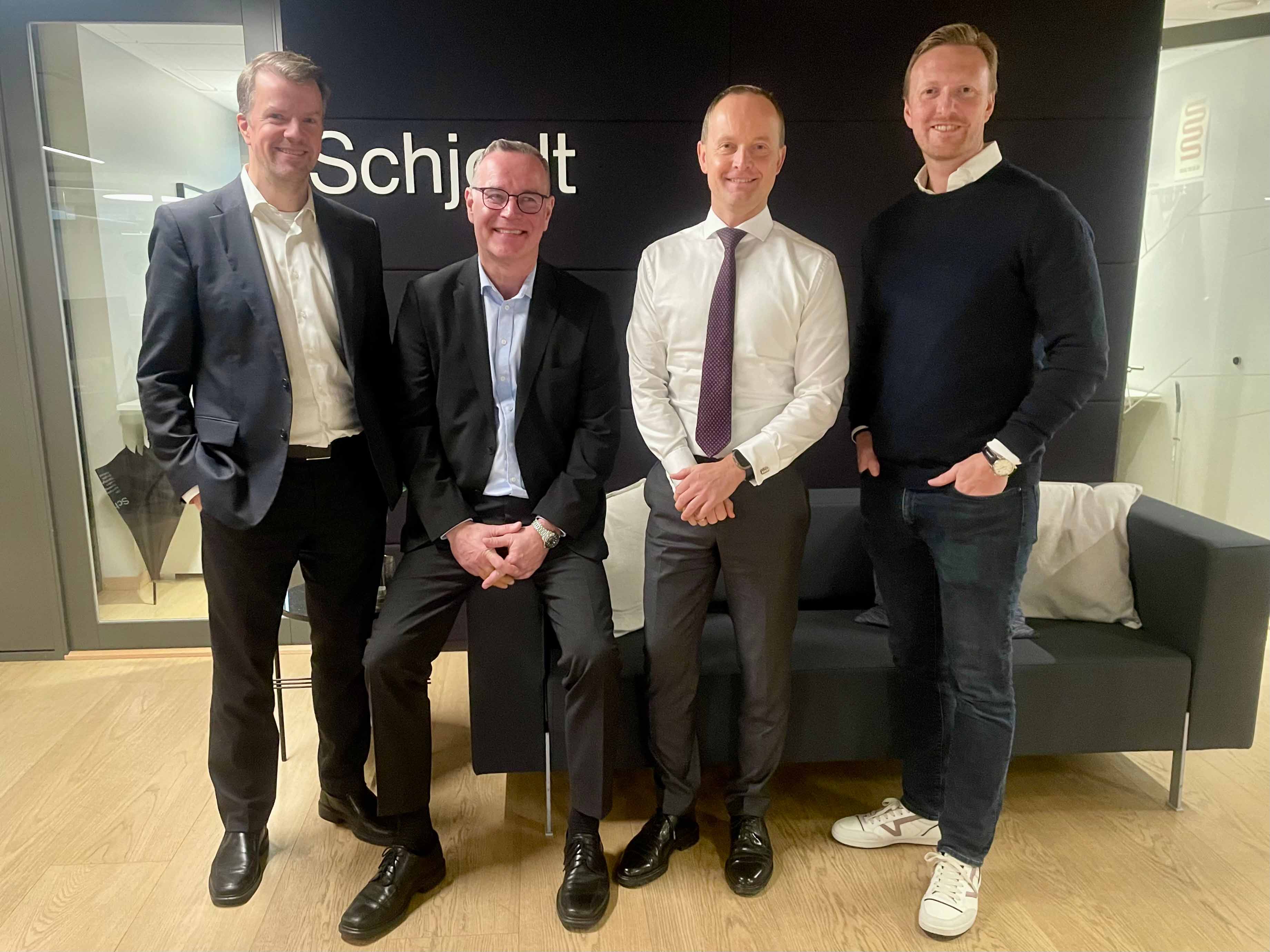 Vier Männer stehen zusammen im Büro von Schjødt in Stavanger: Atle Gjertsen von Achilles, neben Jeppe Songe-Møller, Morten Lillesand und Andrew Mitchell von Orpheus.