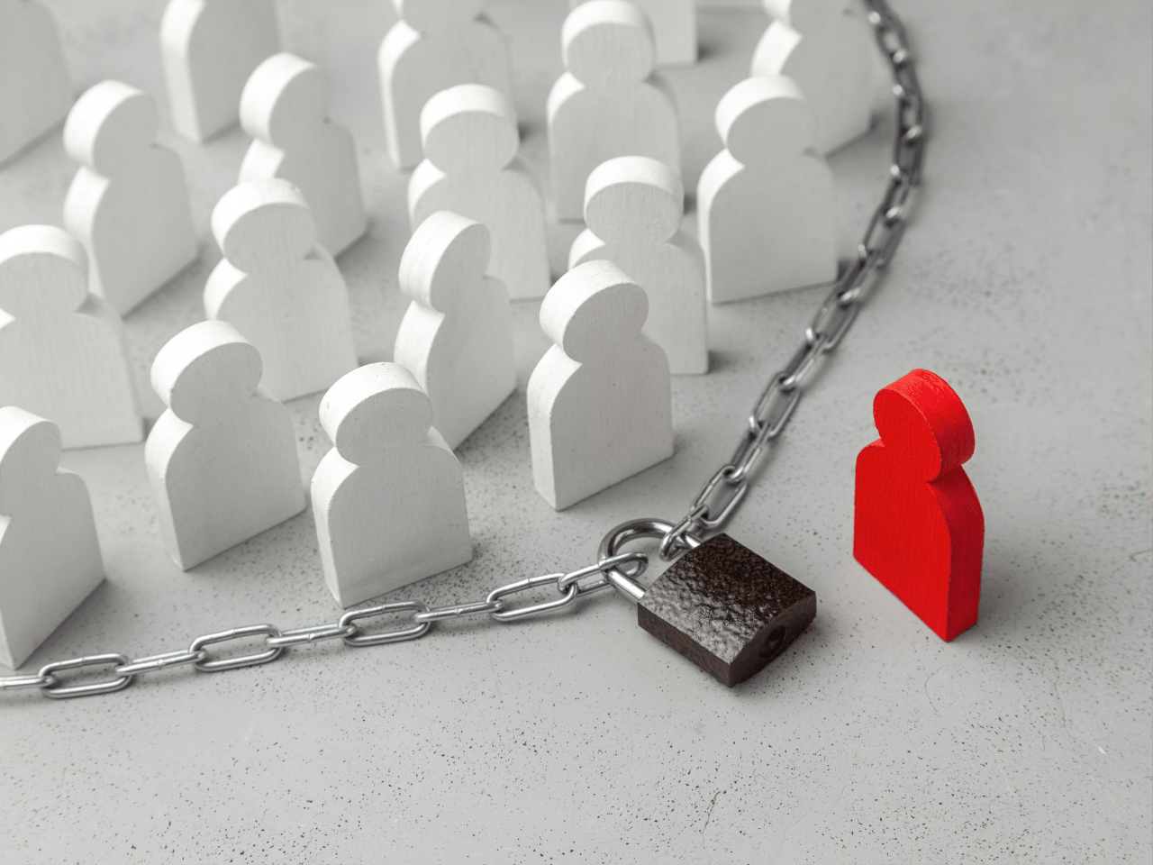 Wooden figures separated by a chain and padlock, representing modern slavery risks in Australian supply chains.