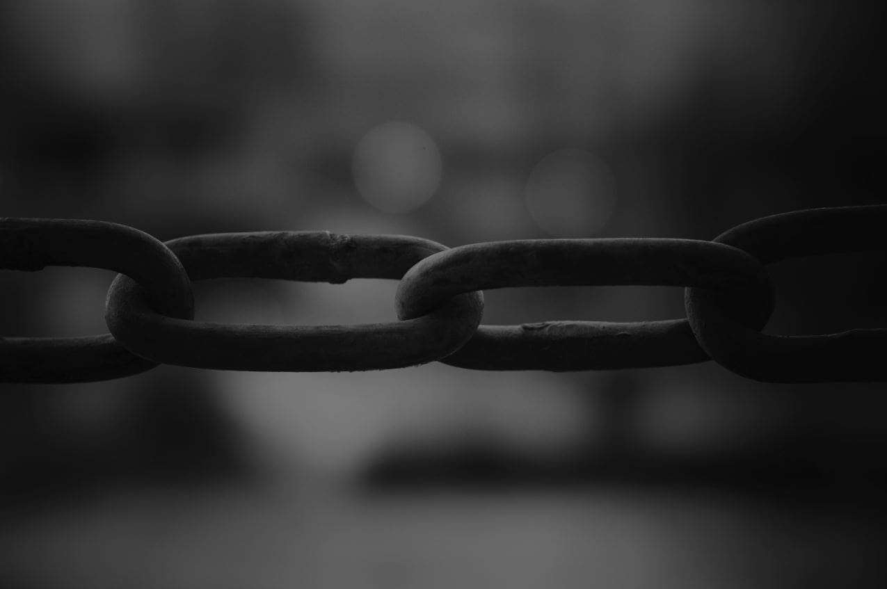 Dark metal chain symbolising hidden modern slavery risks across global supply chains.
