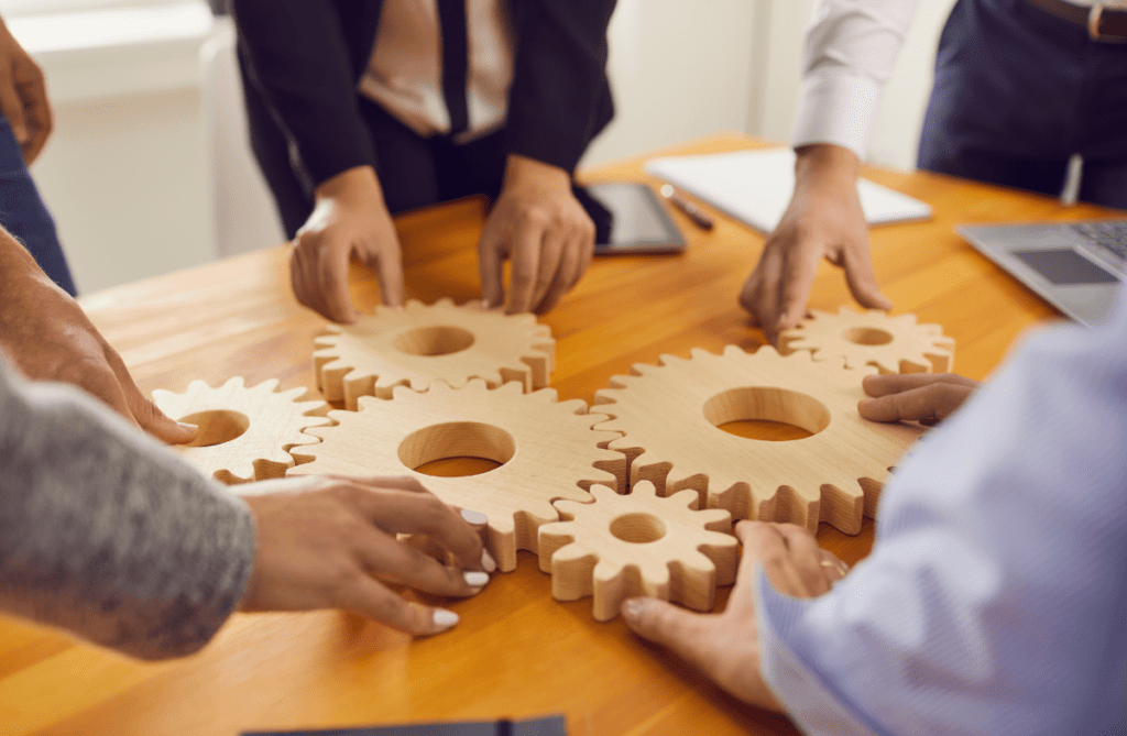 cogs on a table and professionals discussing procurement